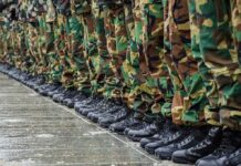 Row of soldiers in camouflage pants and black boots