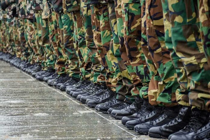 Row of soldiers in camouflage pants and black boots