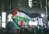 Palestinian flag waved at a nighttime street protest