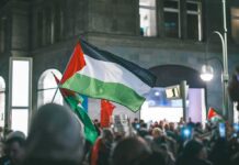 Palestinian flag waved at a nighttime street protest