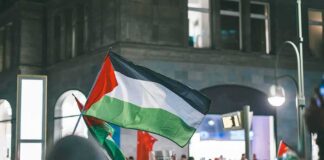 Palestinian flag waved at a nighttime street protest