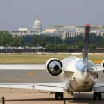 Aging Government Jet Suffers Midair Engine Failure Private jet on airport taxiway with U.S. Capitol in background