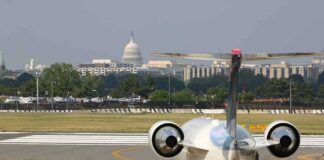 Private jet on airport taxiway with U.S. Capitol in background