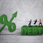 Japan’s Debt Gamble: Market Chaos Looms Three people pulling rope tied to rising percent sign beside large debt text