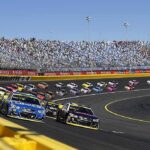 Sudden Death at 41 — What Happened to Kyle Busch? Stock cars racing on a banked track with grandstands in background