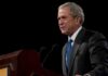 George W. Bush speaking at a podium with microphones
