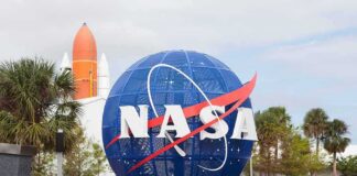 NASA globe sign at visitor center with space shuttle booster in background