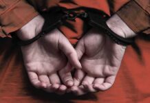 Clemency Crushed – Clock Ticks in Tennessee person in handcuffs with hands behind back