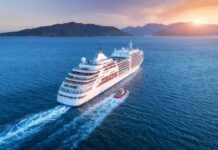 Live-At-Sea Dream Implodes In Cambodia Cruise ship sailing at sunset near mountainous coast