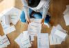 Person sitting on floor sorting bills and invoices