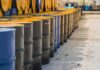 Rows of industrial metal barrels with yellow lids