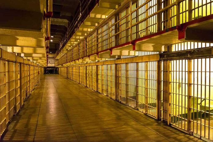 Prison cell block corridor with barred cells and upper walkways