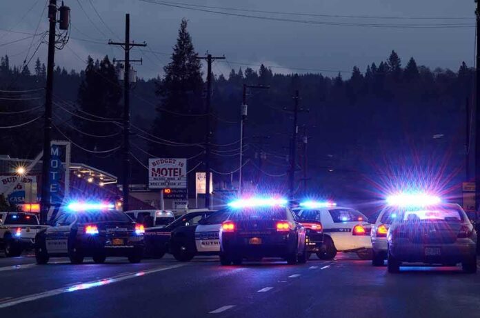 Police cars with flashing lights block a road at night