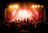 No-Politics Claim Meets Brutal Reality concert crowd under bright stage lights