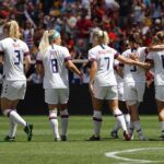 Girls Protest – No Punishment, Bigger Fight Looms Alex Morgan, Crystal Dunn, Christian Jones, and Walter Jones among teammates celebrating on a soccer field