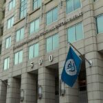 Shock Move: Reuniting First, Then Removal U.S. government building facade with American and blue departmental flags