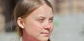 young woman with braid looking to the side outdoors