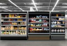 Supermarket refrigerated display cases with drinks, produce, and prepared foods