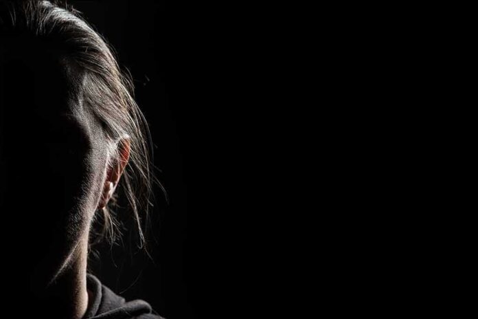 shutterstock_1912869817 silhouette of a person's face in low-key lighting