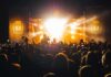 One Alarming Phone Call Silences a Packed Arena Crowd at a nighttime concert with bright stage lights