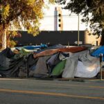 A Housing Revolt Just Moved Into the Square Street encampment with tarps and makeshift tents by roadside