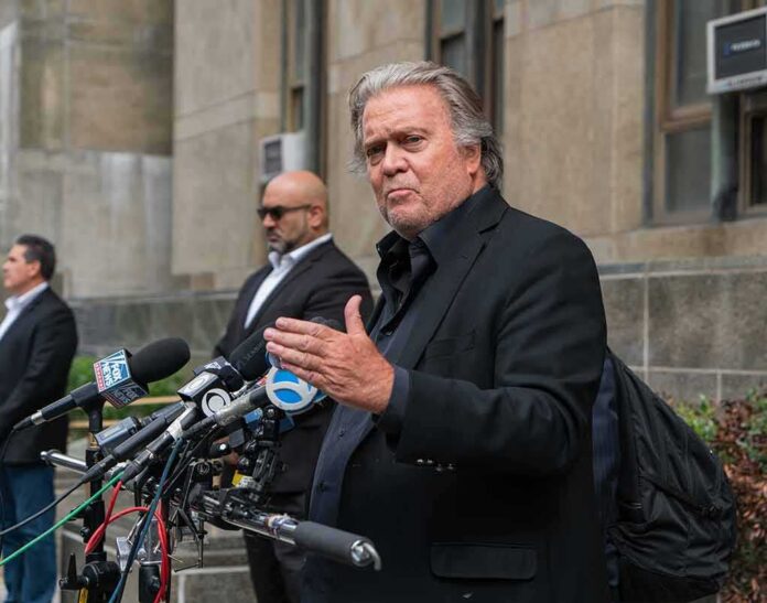 Steve Bannon speaks at a press conference with multiple microphones outside a building
