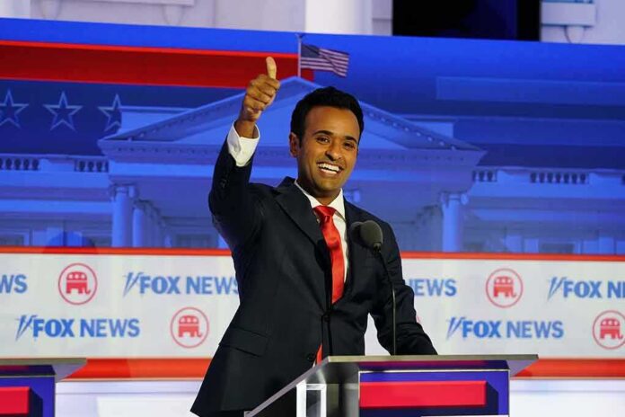 shutterstock_2351694243 smiling man in suit at debate podium giving thumbs up