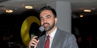 Zohran Mamdani speaking into a microphone