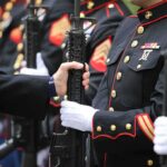 Marines in dress uniforms holding rifles during a ceremony