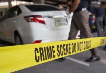 Wine-Fueled Dive Off Cliff – Children Inside Yellow crime scene tape in front of a white car with investigators nearby