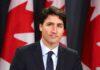 Language Police Drama Grips Trudeau Cabinet man in suit at podium with Canadian flags