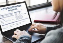 Person using a laptop to fill out a vote registration form