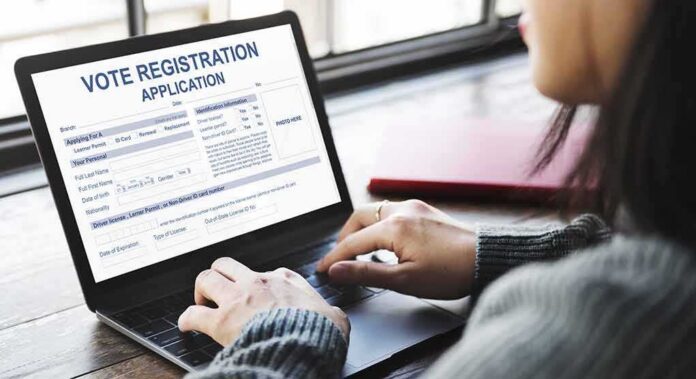 shutterstock_481648579 Person using a laptop to fill out a vote registration form