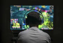 Gamer wearing headphones playing on a large screen