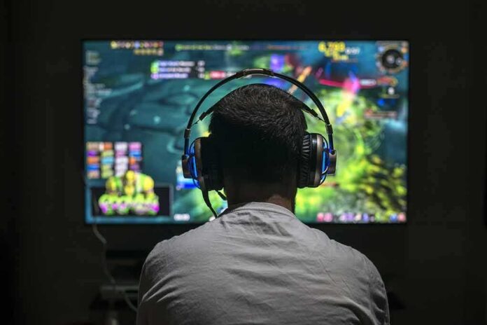 shutterstock_634861250 Gamer wearing headphones playing on a large screen