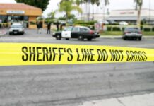 Governor Under Fire After Street Attack yellow sheriff's line tape blocks a street near police cars